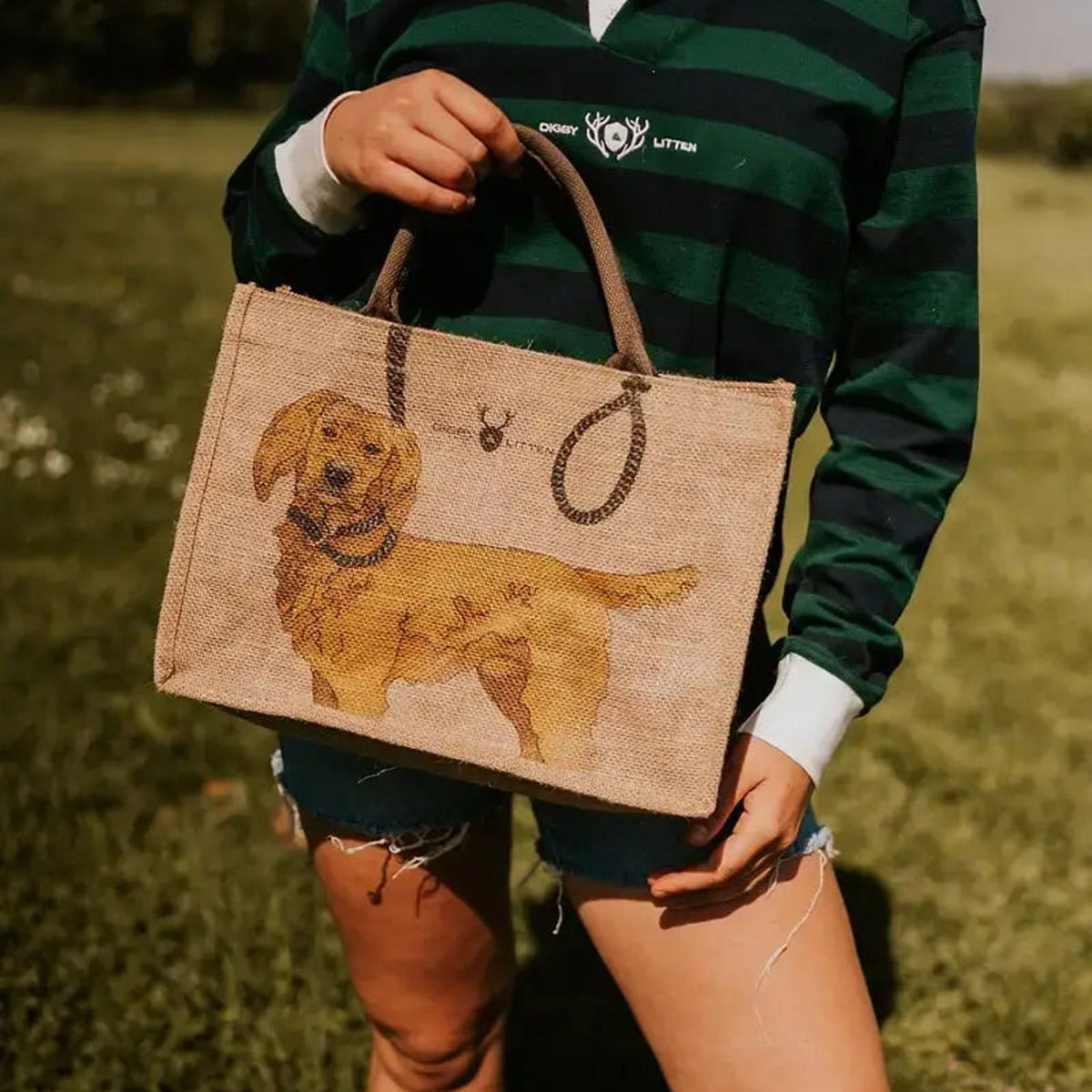 Digby &amp; Litten tote bag carried by its handles, showing the illustrated dog design.