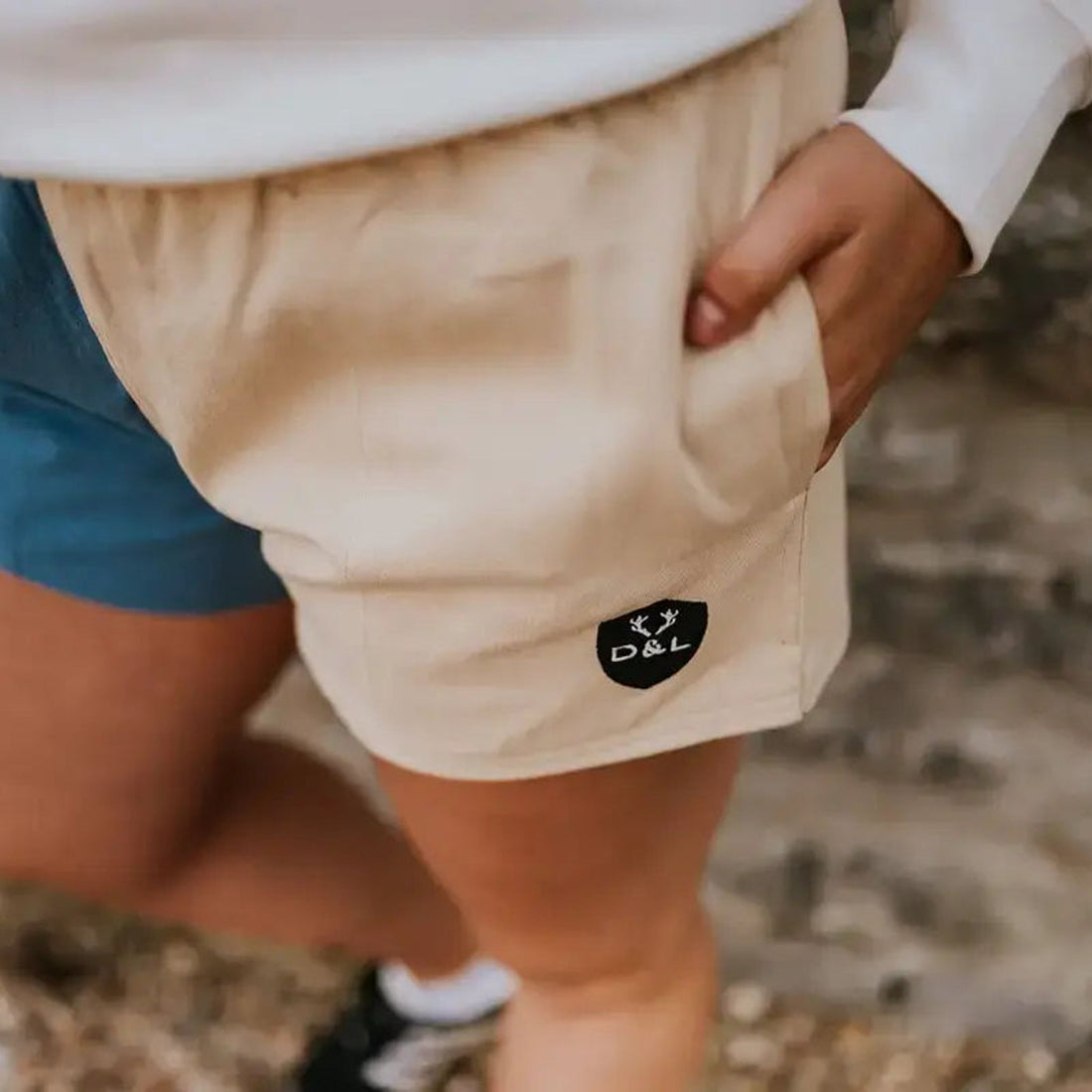 Blue and cream rugby shorts shown worn, with a close-up of the cream panel and D&amp;L badge.